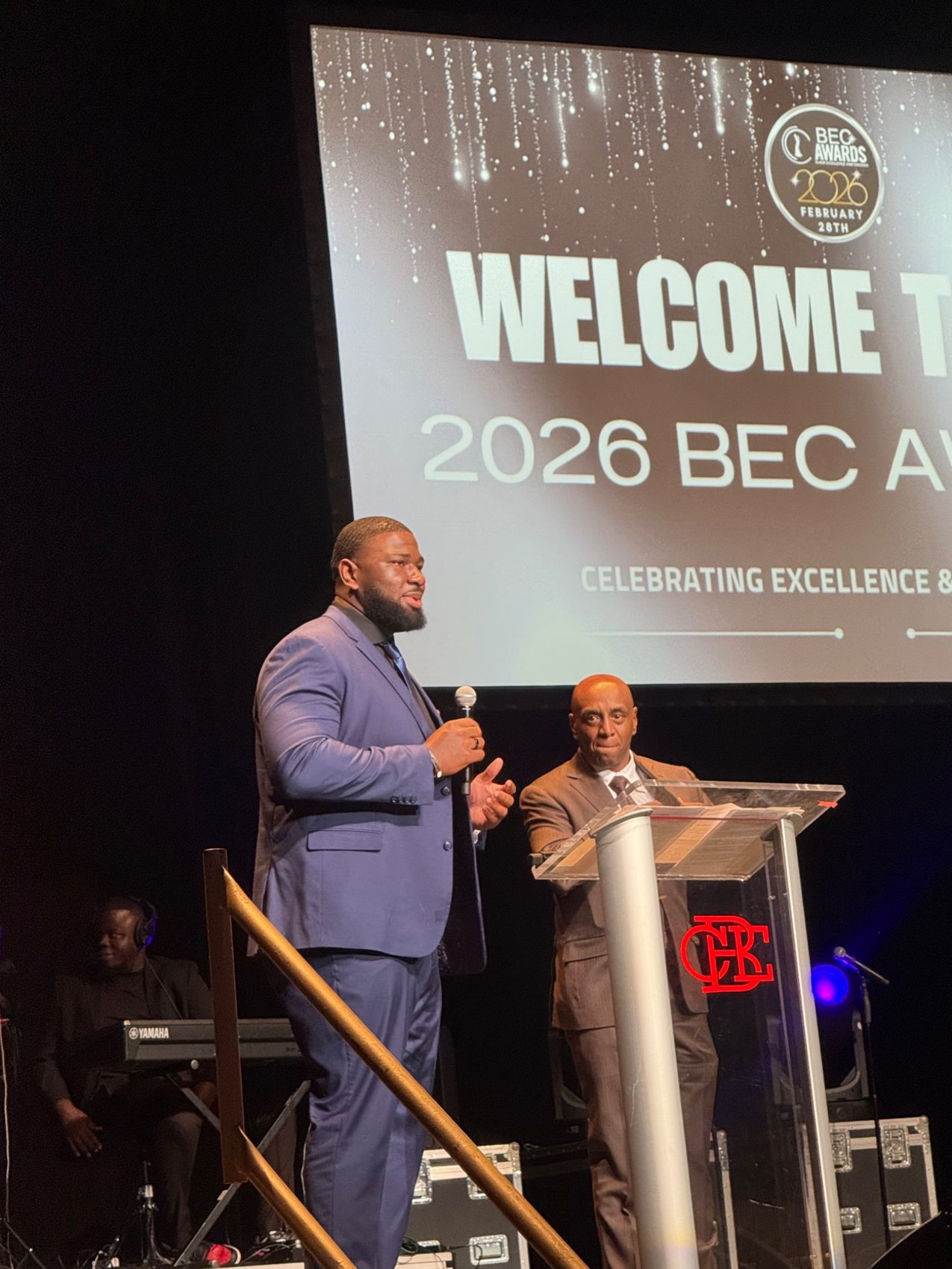 McClendon Curtis speaking on stage at an awards event